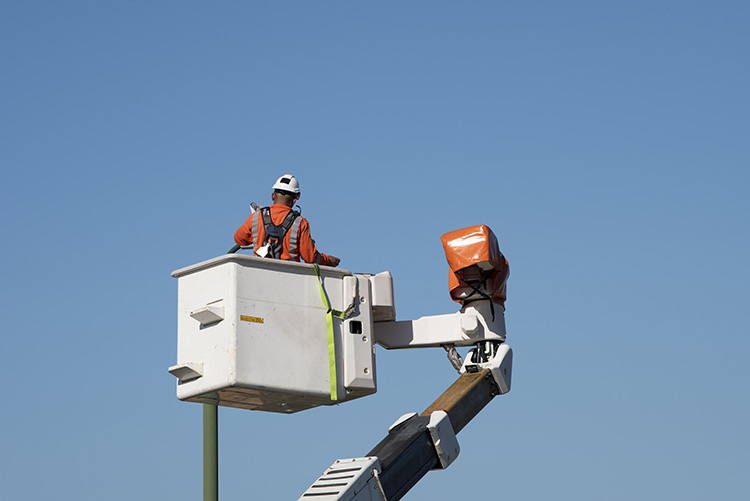 Electrical worker maintaining outdoor lighting with a bucket truck